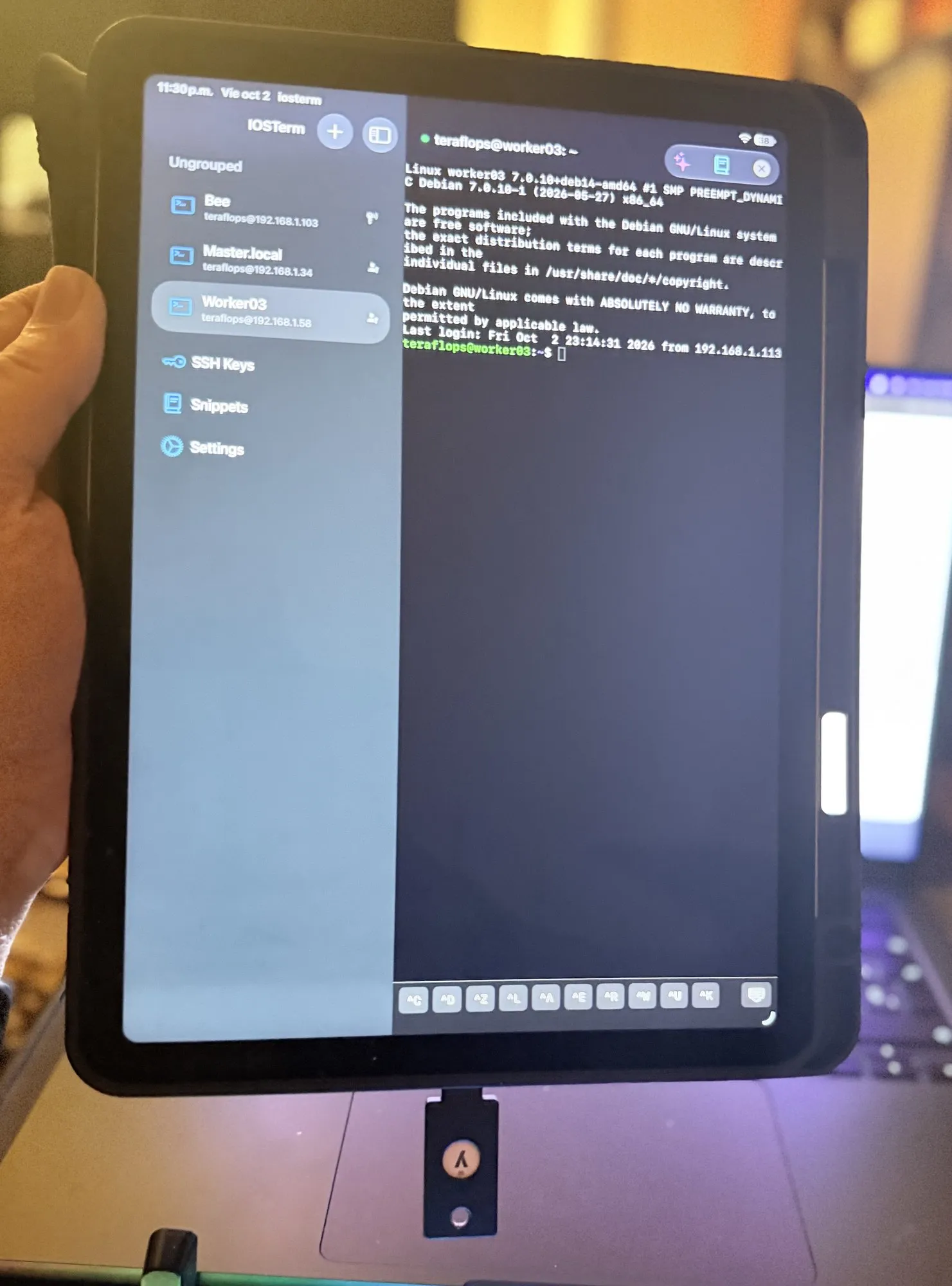 A YubiKey 5C NFC plugged into an iPad's USB-C port while IOSTerm shows an SSH session on worker03 that was opened with it